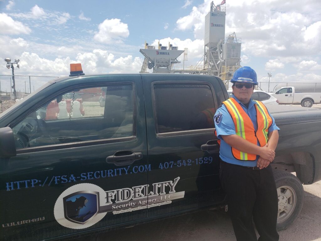 Security officer standing beside a branded patrol vehicle